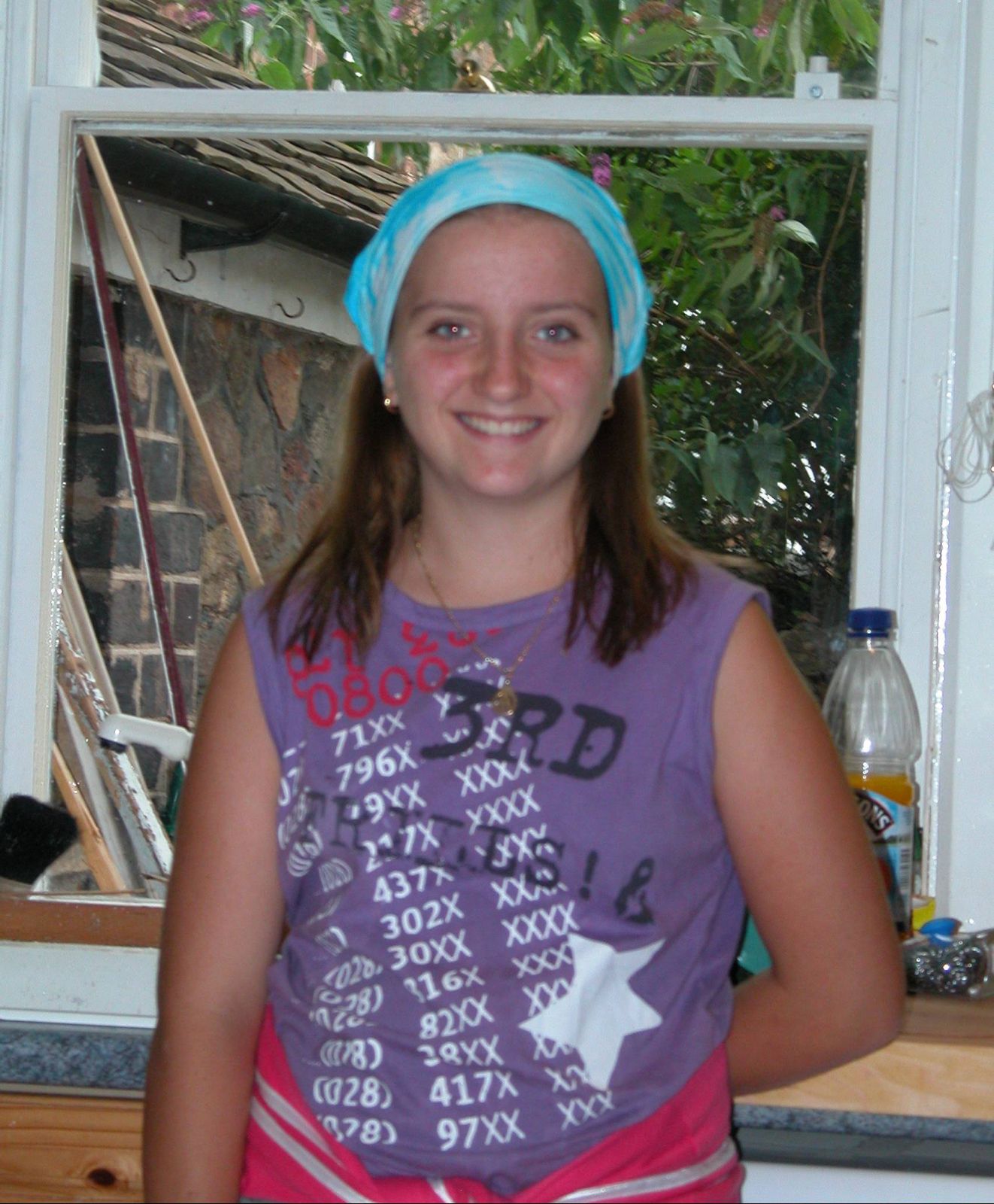Ami as a child in the family kitchen wearing a blue bandana