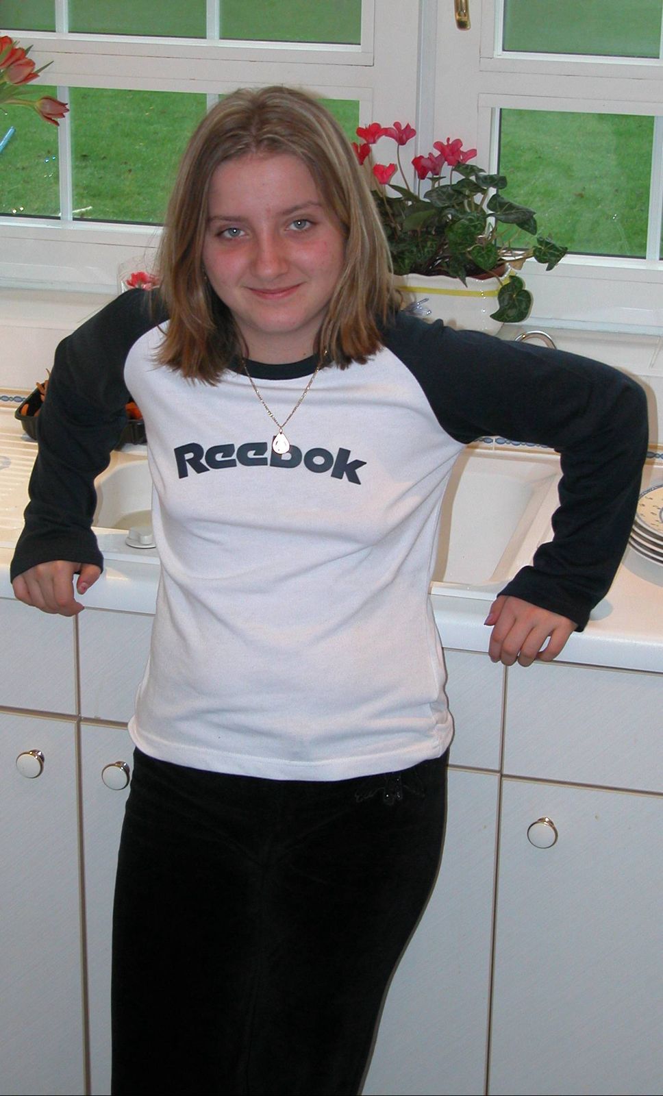 Ami as a child in the kitchen wearing a Reebok top