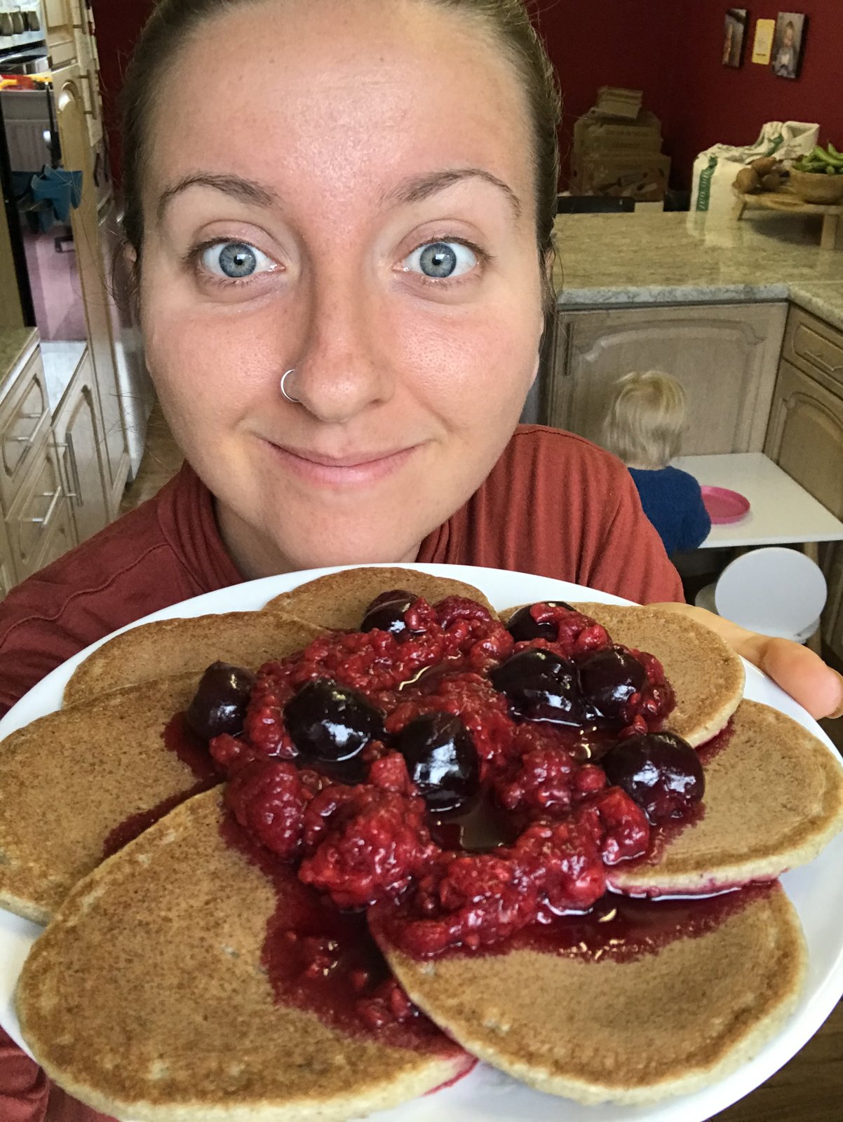 Ami holding a plate of pancakes with berry sauce she posted in July 2020